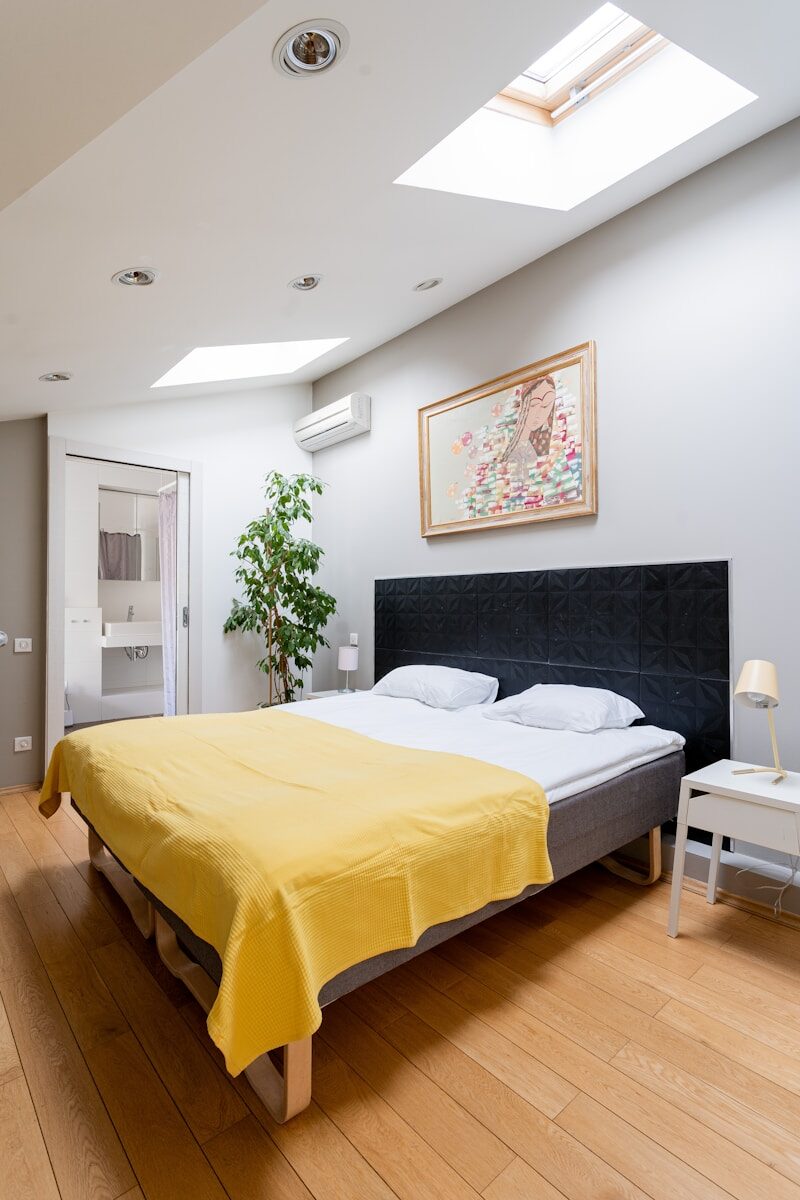 a bedroom with a bed and a yellow blanket